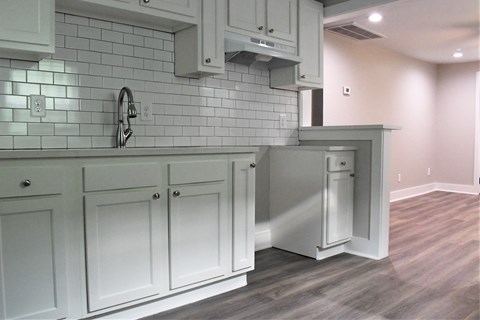 a view of a kitchen with white cabinets and white subway tile